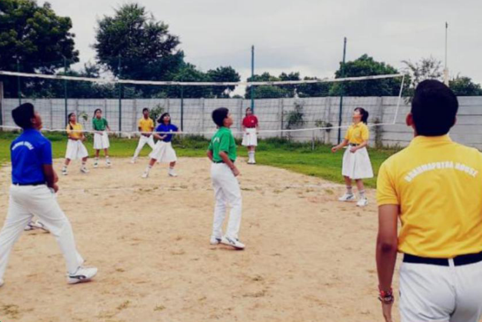 Students playing volleyball on an outdoor court